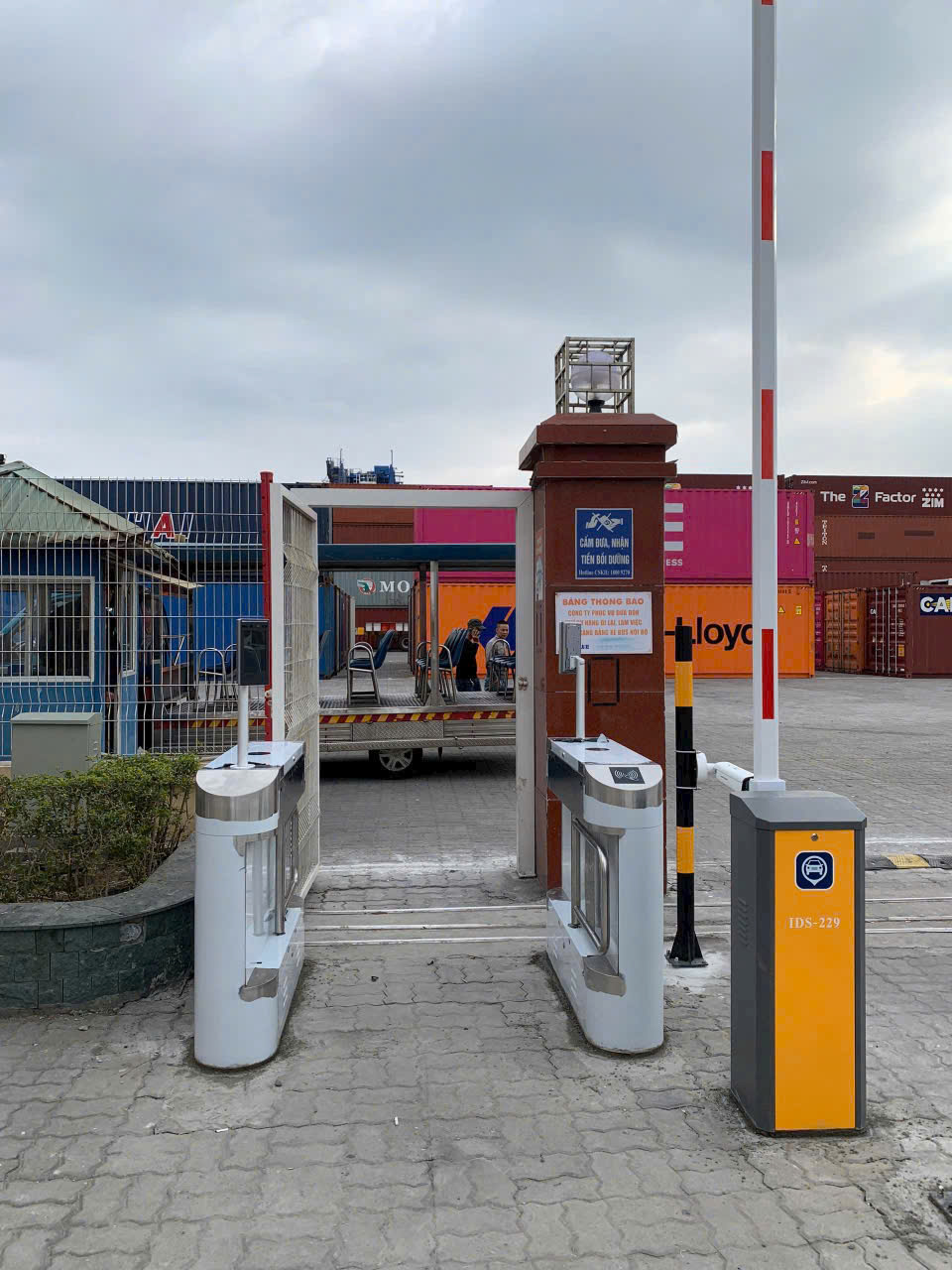 Cổng kiểm soát ra vào tự động với barie và máy quét thẻ tại khu vực kho bãi container